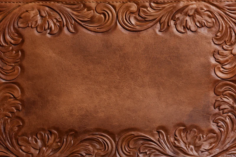 Tooled leather surface with embossed floral border in flat lay arrangement