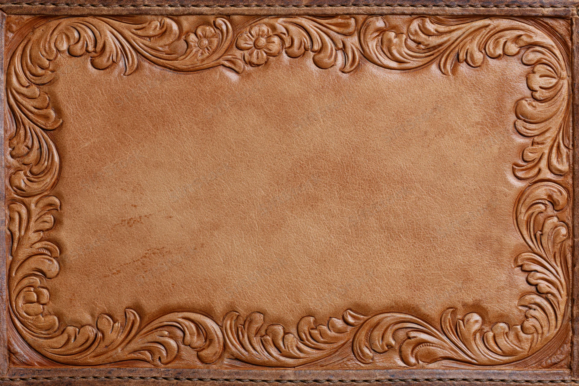 Tooled leather surface with embossed floral border and central copyspace