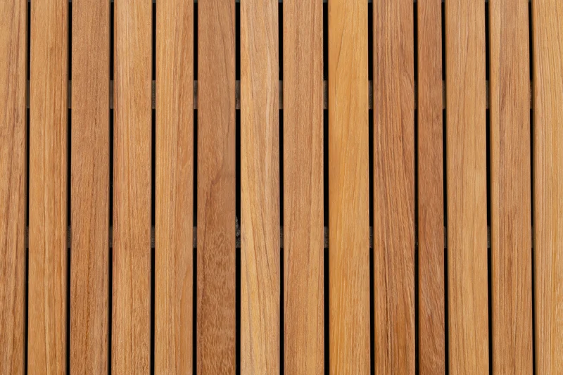 Vertical teak wood planks arranged in a flat lay close-up view