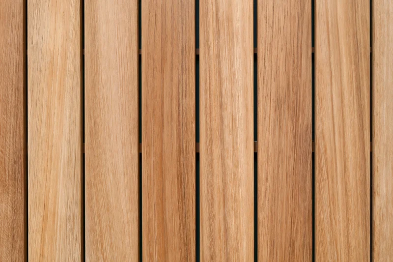 Vertical teak wood planks arranged in parallel rows forming a flat surface