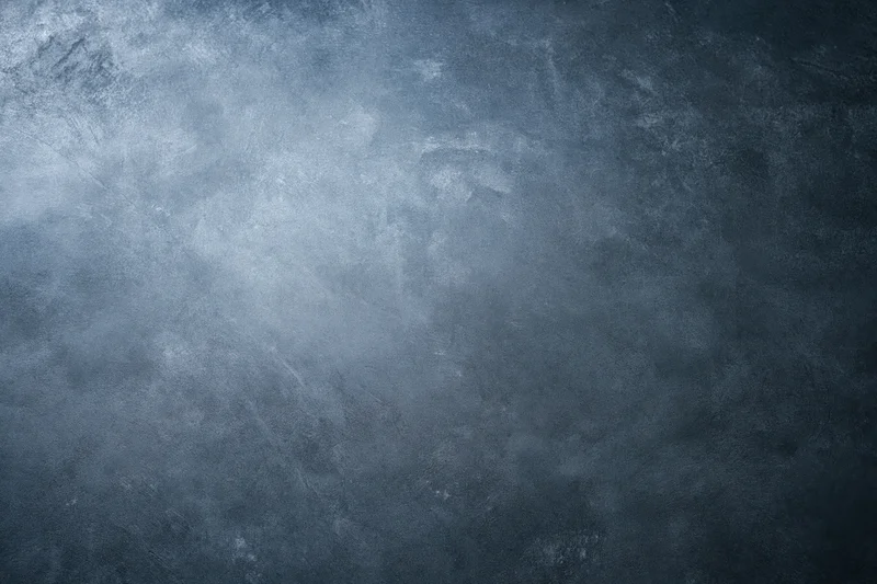 Close-up of a bare concrete wall surface with rough texture and gray-blue tones filling the frame