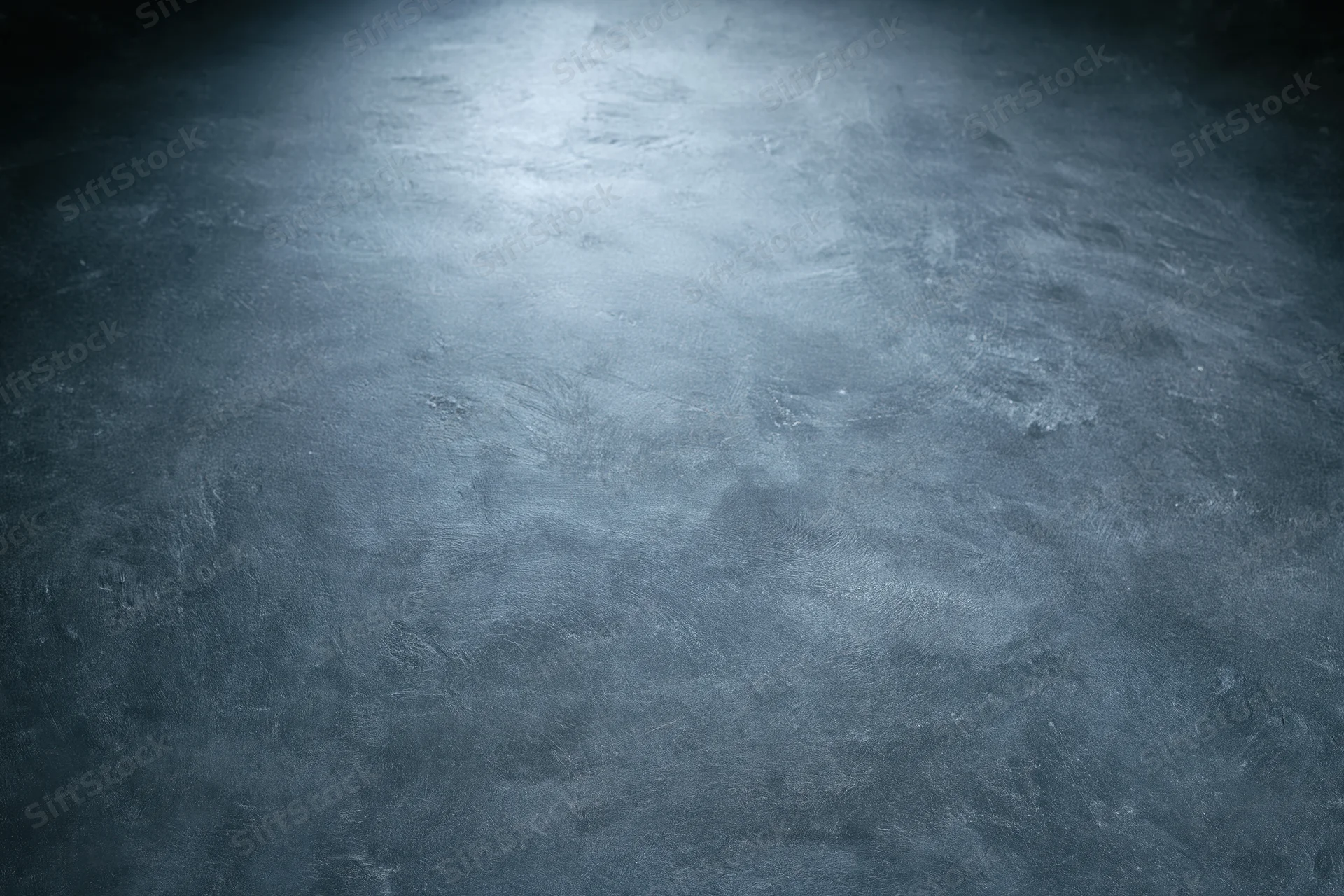 Close-up of a rough concrete wall surface with spotlight and vignette effect