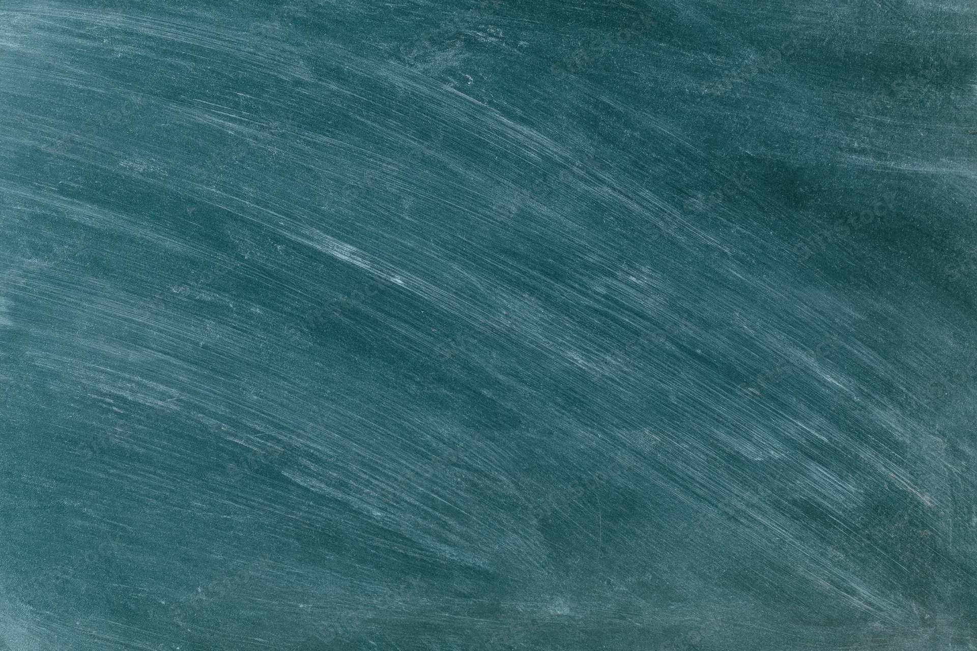 Close-up of a blank chalkboard surface with chalk residue and diagonal smudges in a classroom setting