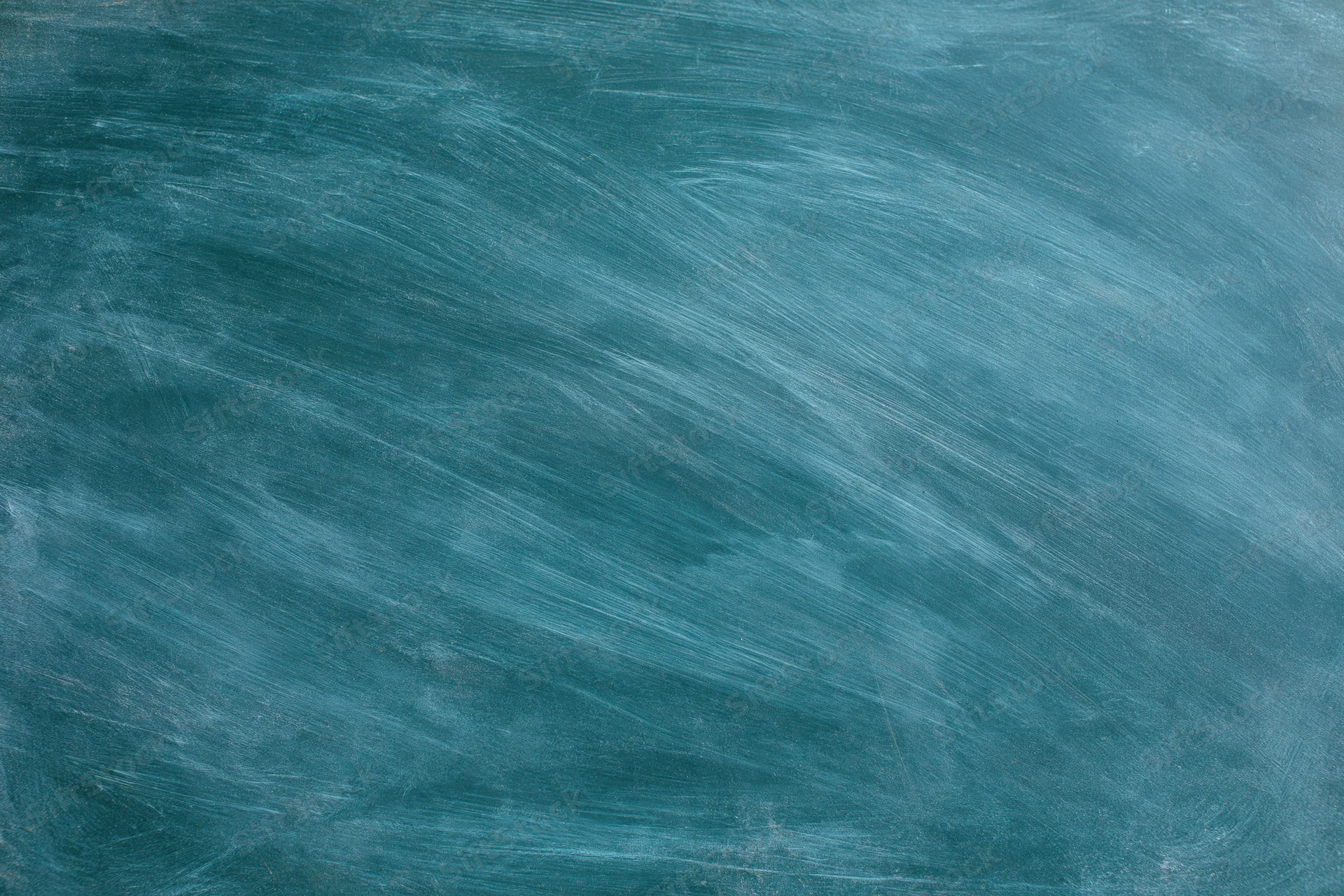 Blank chalkboard surface with smudged white residue in a classroom setting