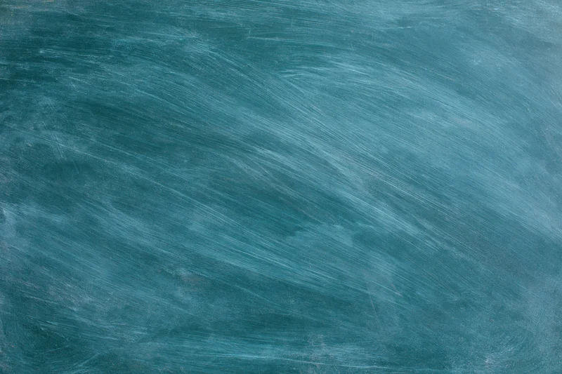 Blank chalkboard surface with smudged white residue in a classroom setting