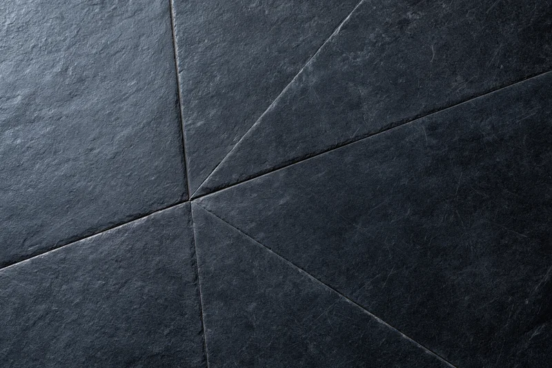Dark slate wall surface with geometric tile pattern and visible grout lines