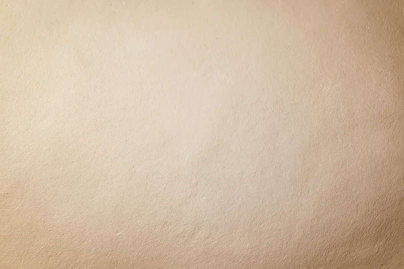 Close-up of a plain painted concrete wall surface with smooth texture and neutral beige tone