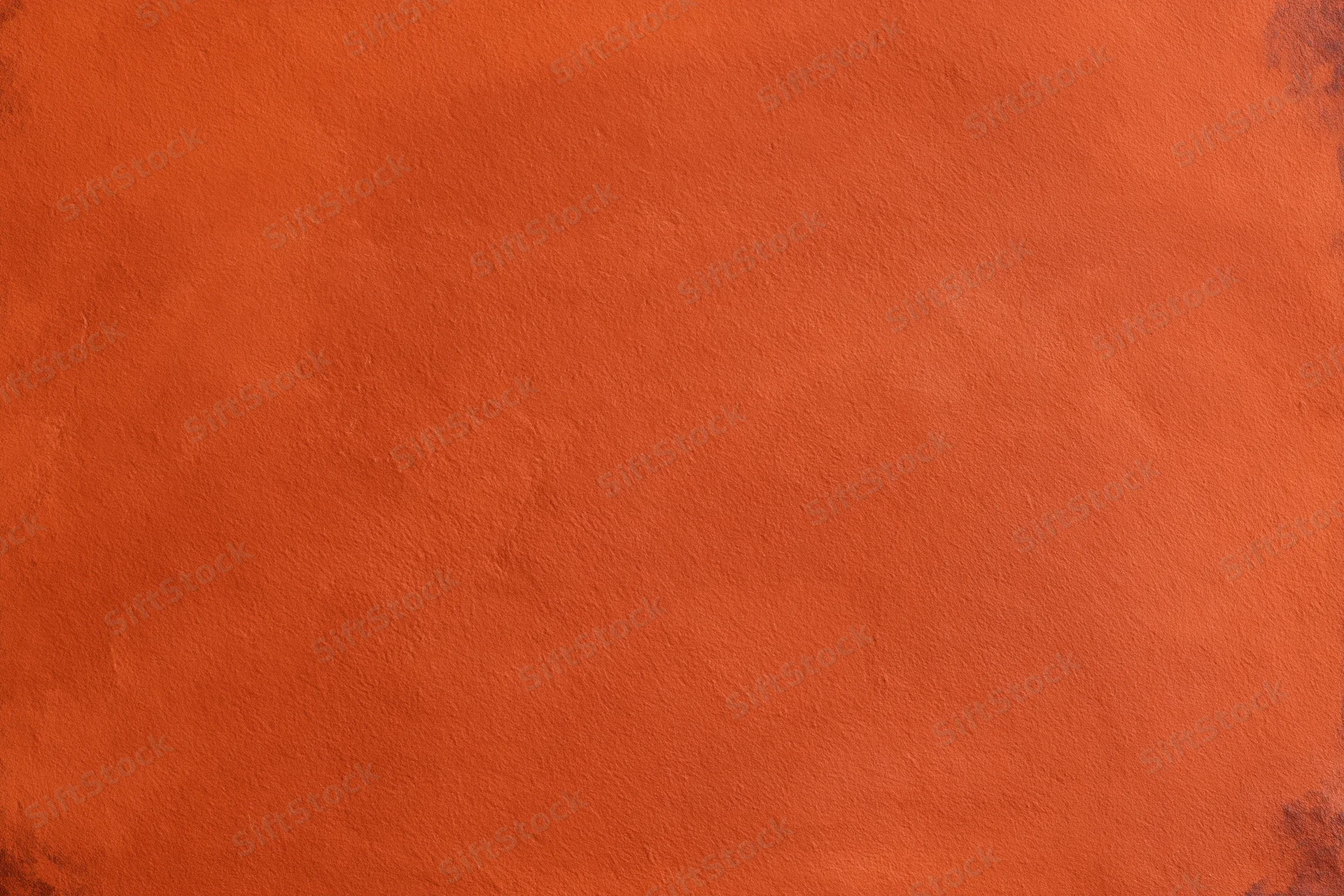 Close-up of an orange stucco plaster wall with textured surface