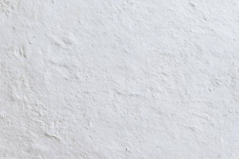 Close-up of a plain white plastered wall surface with textured finish