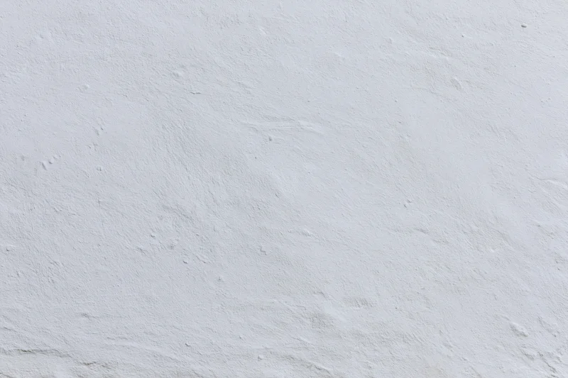 Close-up of a plain white plaster wall with subtle texture and even lighting
