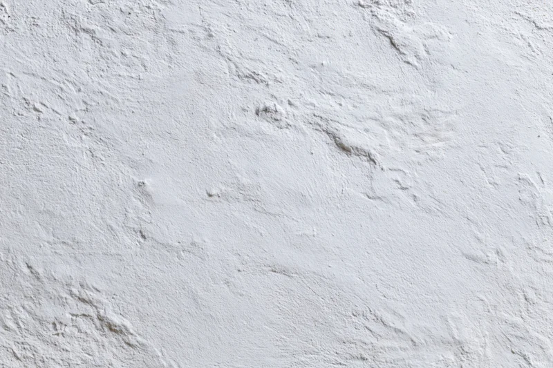 Close-up of a plain white plastered wall with rough texture