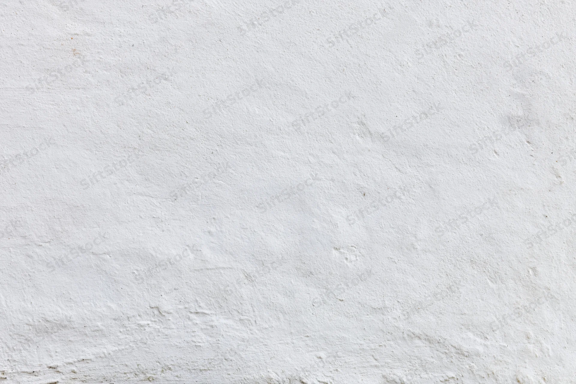 Close-up of a plain white painted concrete wall with textured surface