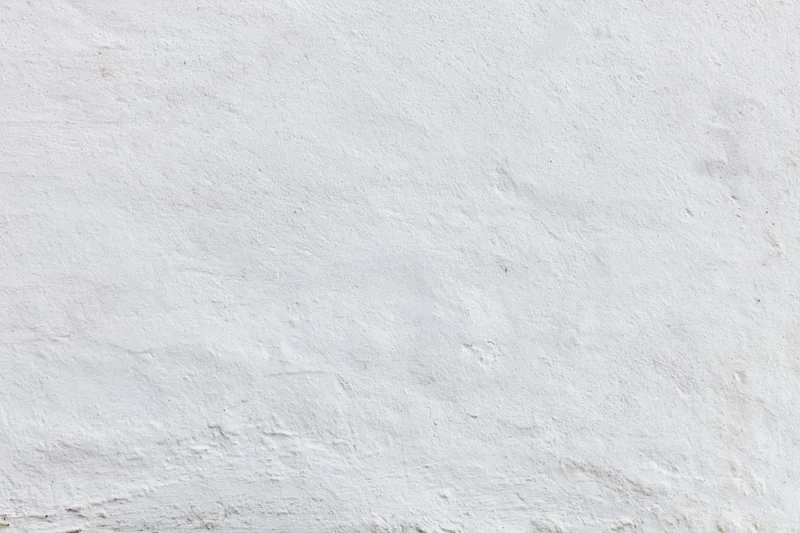 Close-up of a plain white painted concrete wall with textured surface