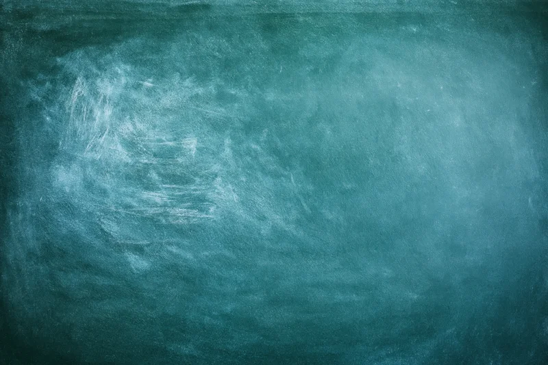 Worn green chalkboard surface with white chalk residue and smudges, flat close-up view