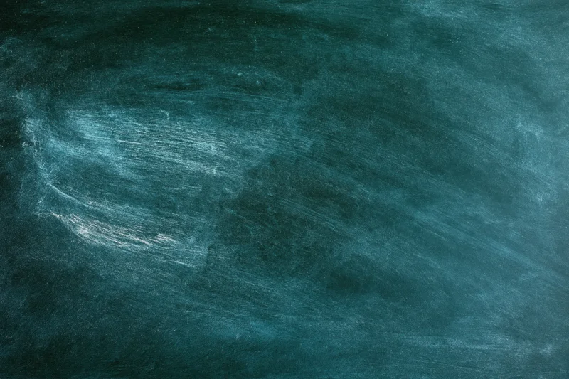 Worn green chalkboard surface with smudged chalk residue and texture, flat close-up view