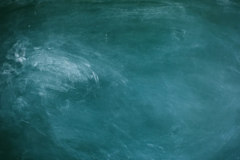 Worn green chalkboard surface with smudged white chalk residue, flat close-up view