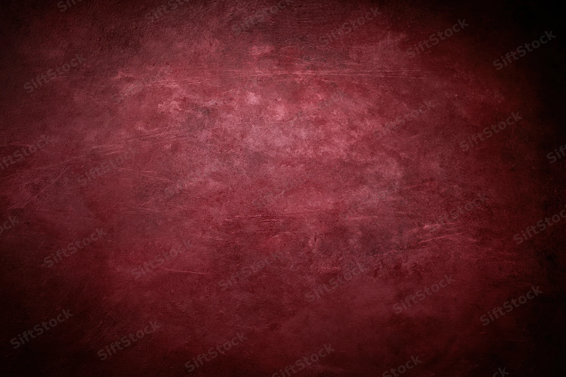 Close-up of an aged red concrete wall surface with textured grunge finish