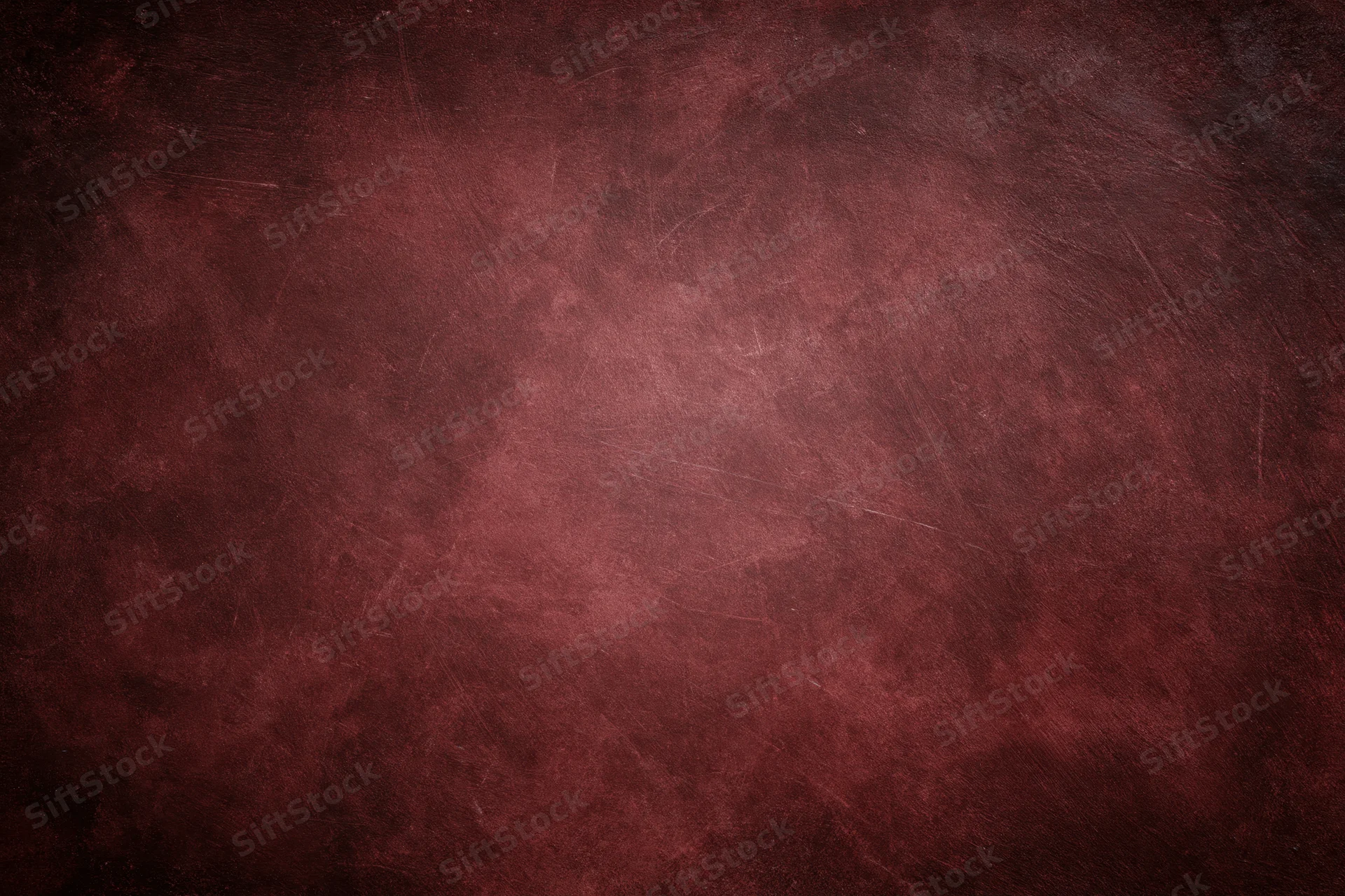 Close-up of an aged red concrete wall surface with visible texture and wear