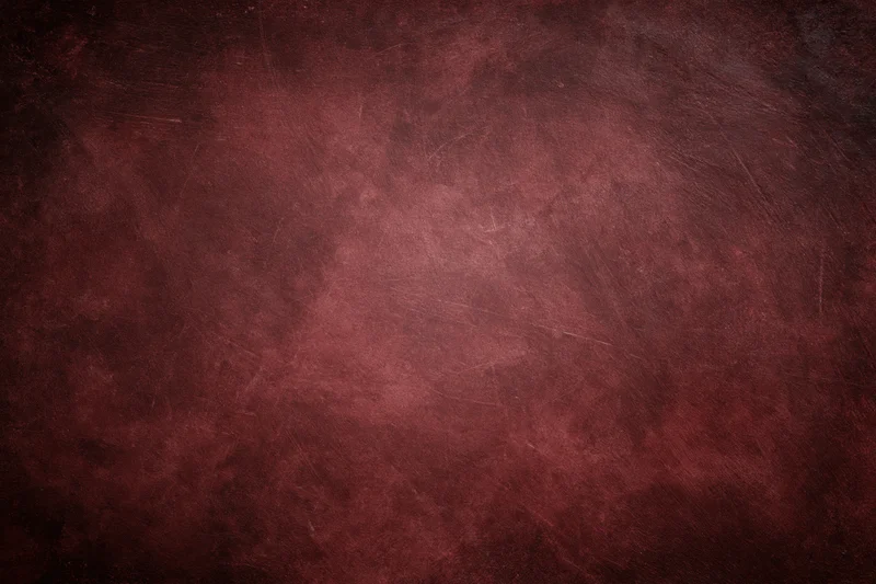 Close-up of an aged red concrete wall surface with visible texture and wear
