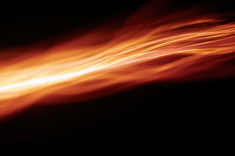 Molten light streaks flowing across dark space in long-exposure photograph