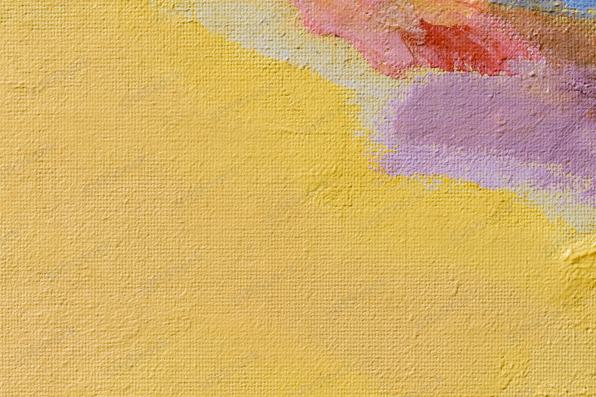 Close-up of a painted canvas surface with textured yellow and multicolored brushstrokes