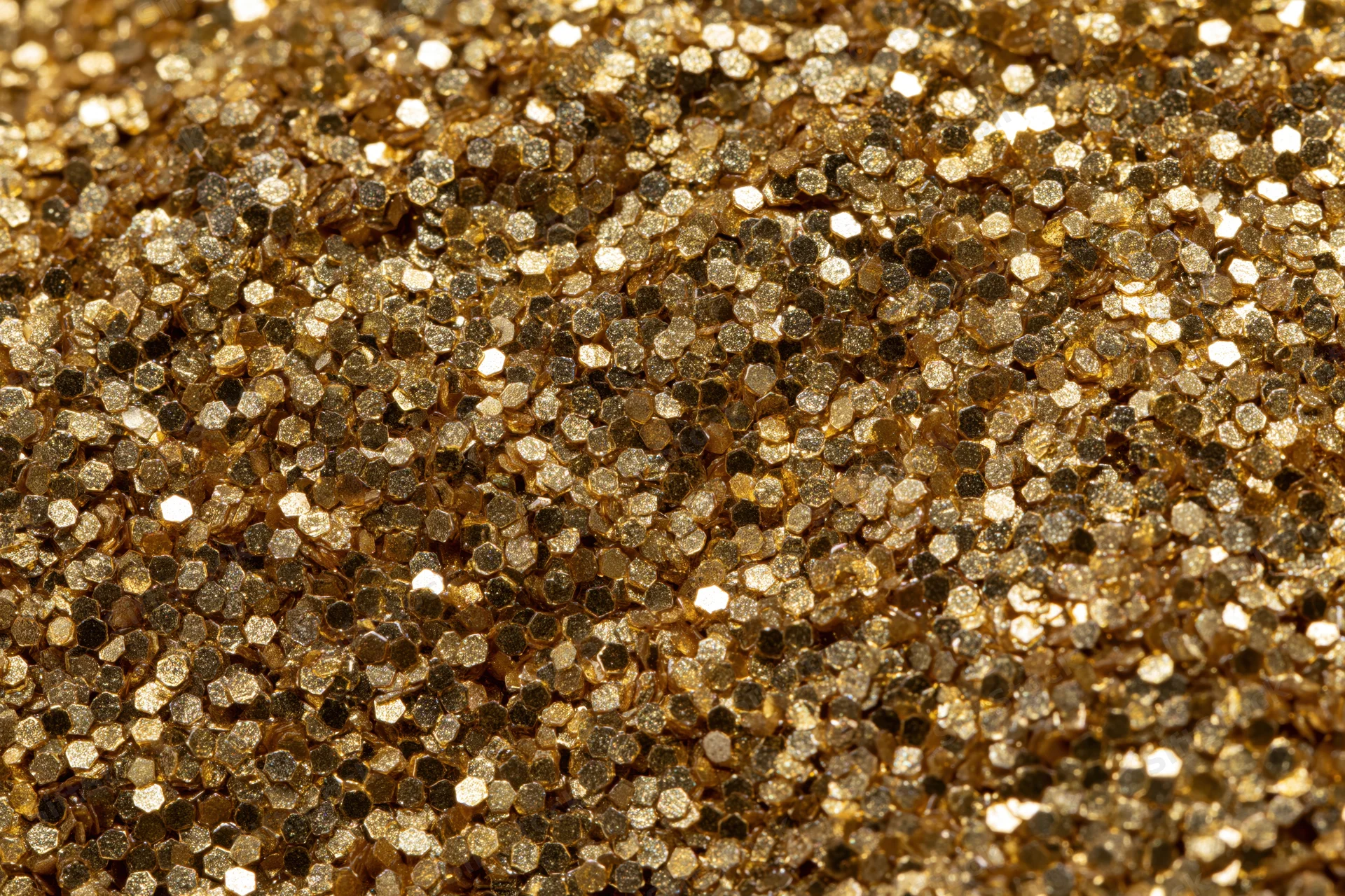 Dense gold glitter particles covering a surface in a close-up macro view