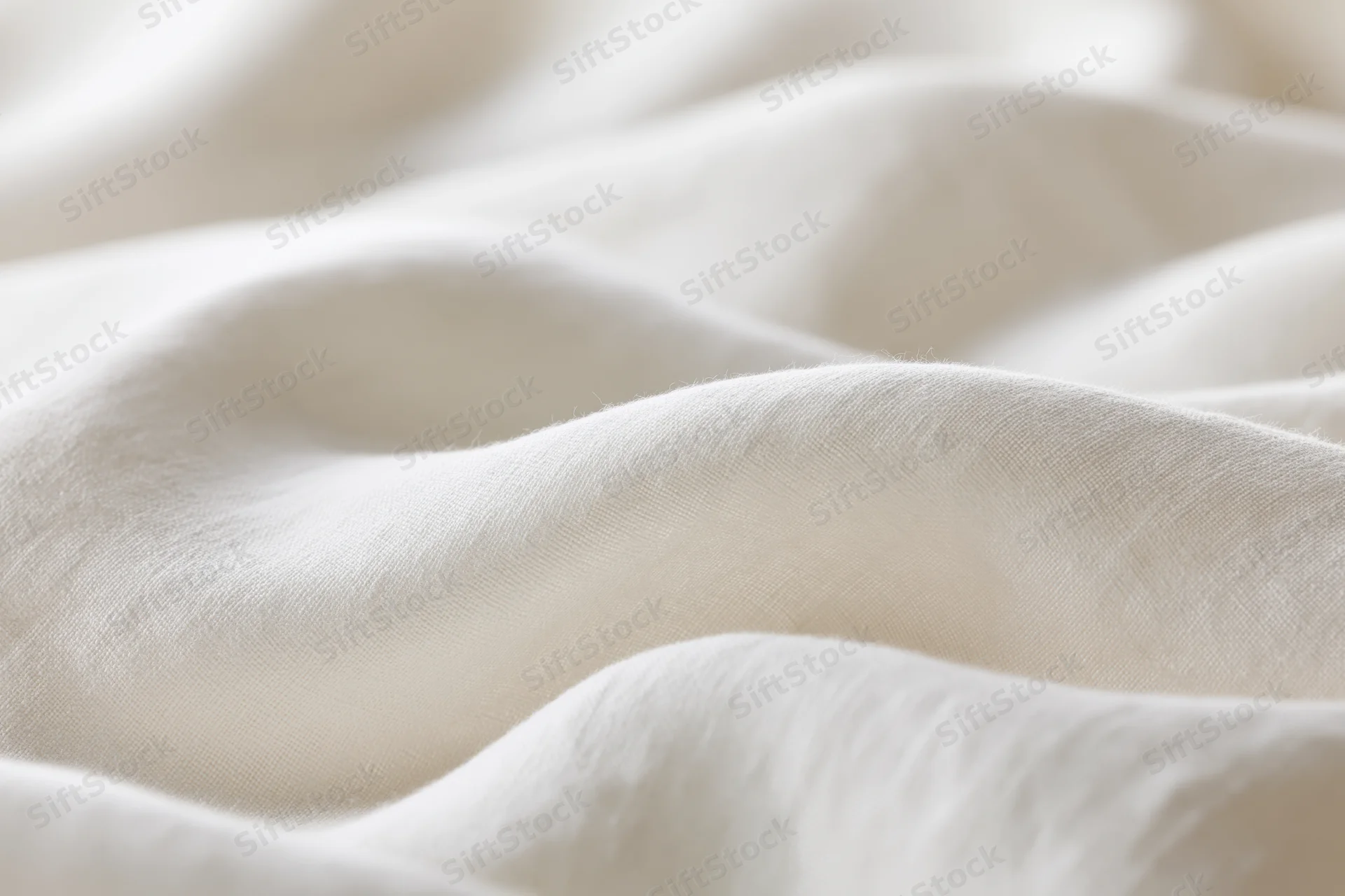 Soft white fabric with gentle folds and natural texture in close-up view