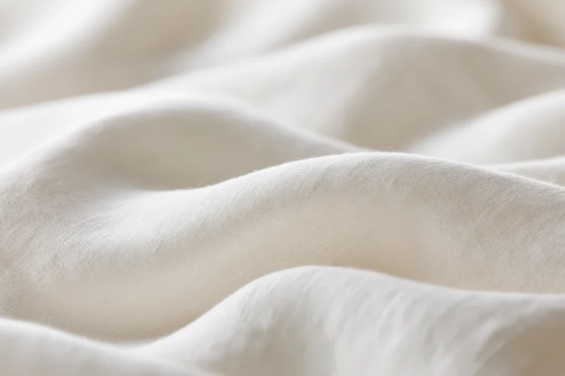 Soft white fabric with gentle folds and natural texture in close-up view