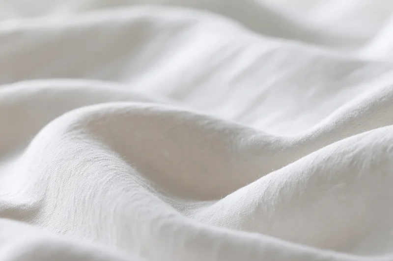 Soft white fabric with gentle folds and natural texture