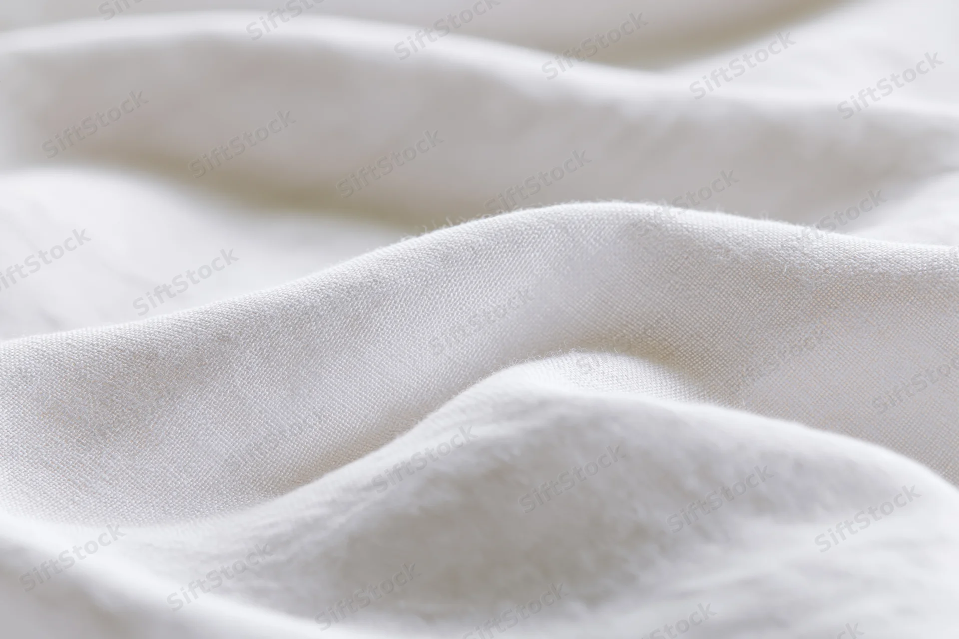 Soft white fabric with gentle folds and natural texture in close-up view