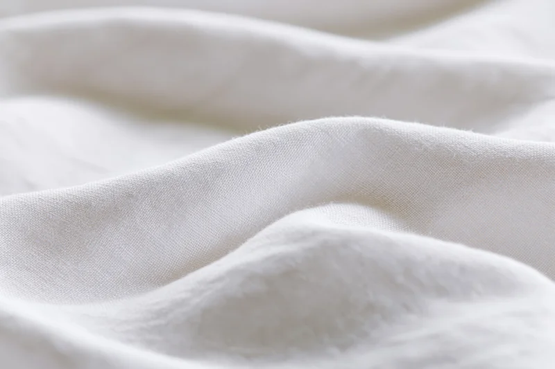 Soft white fabric with gentle folds and natural texture in close-up view