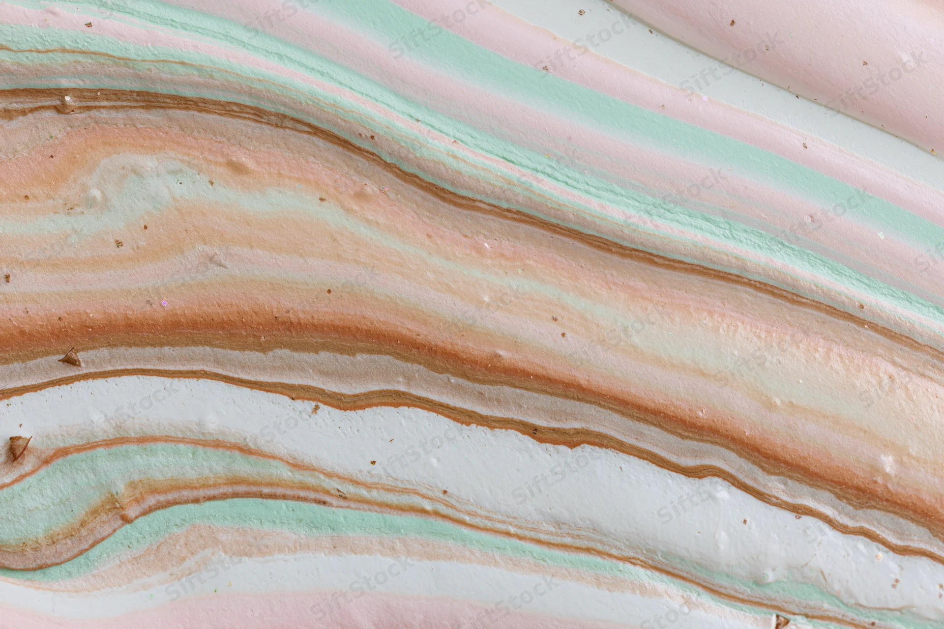 Swirling layers of pastel-colored liquid paint forming an abstract marbled texture