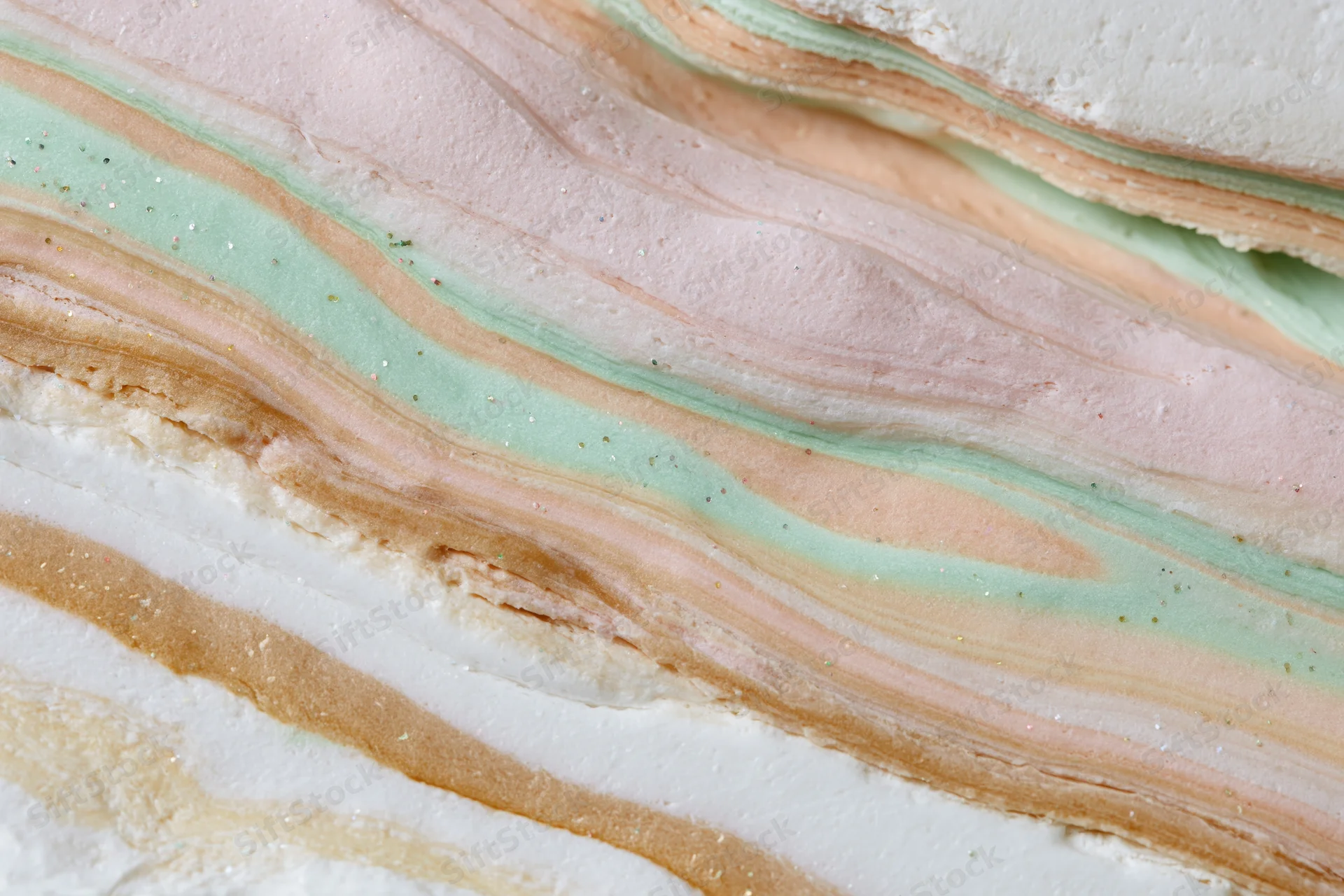 Swirling layers of pastel-colored liquid paint forming a marbled texture in close-up view