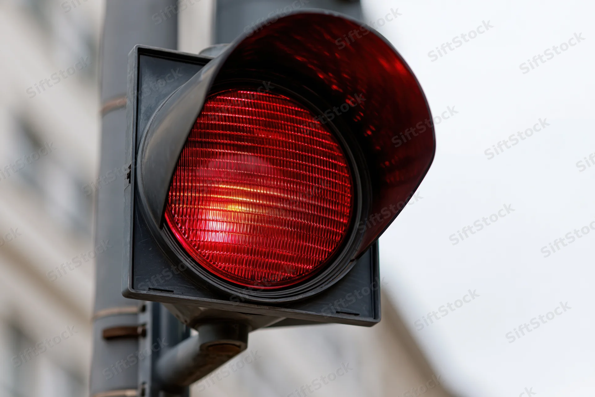 Glowing red traffic light signal in close-up view on city street