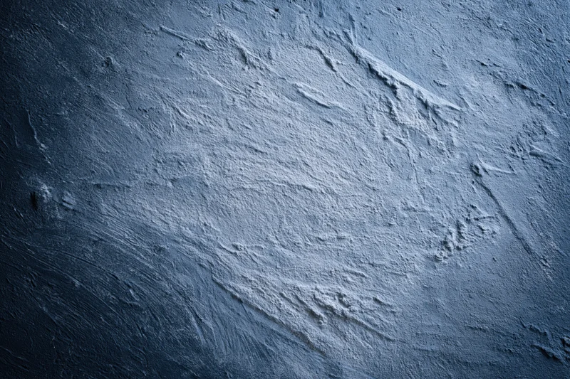 Weathered concrete wall surface with rough texture and visible cracks filling the frame