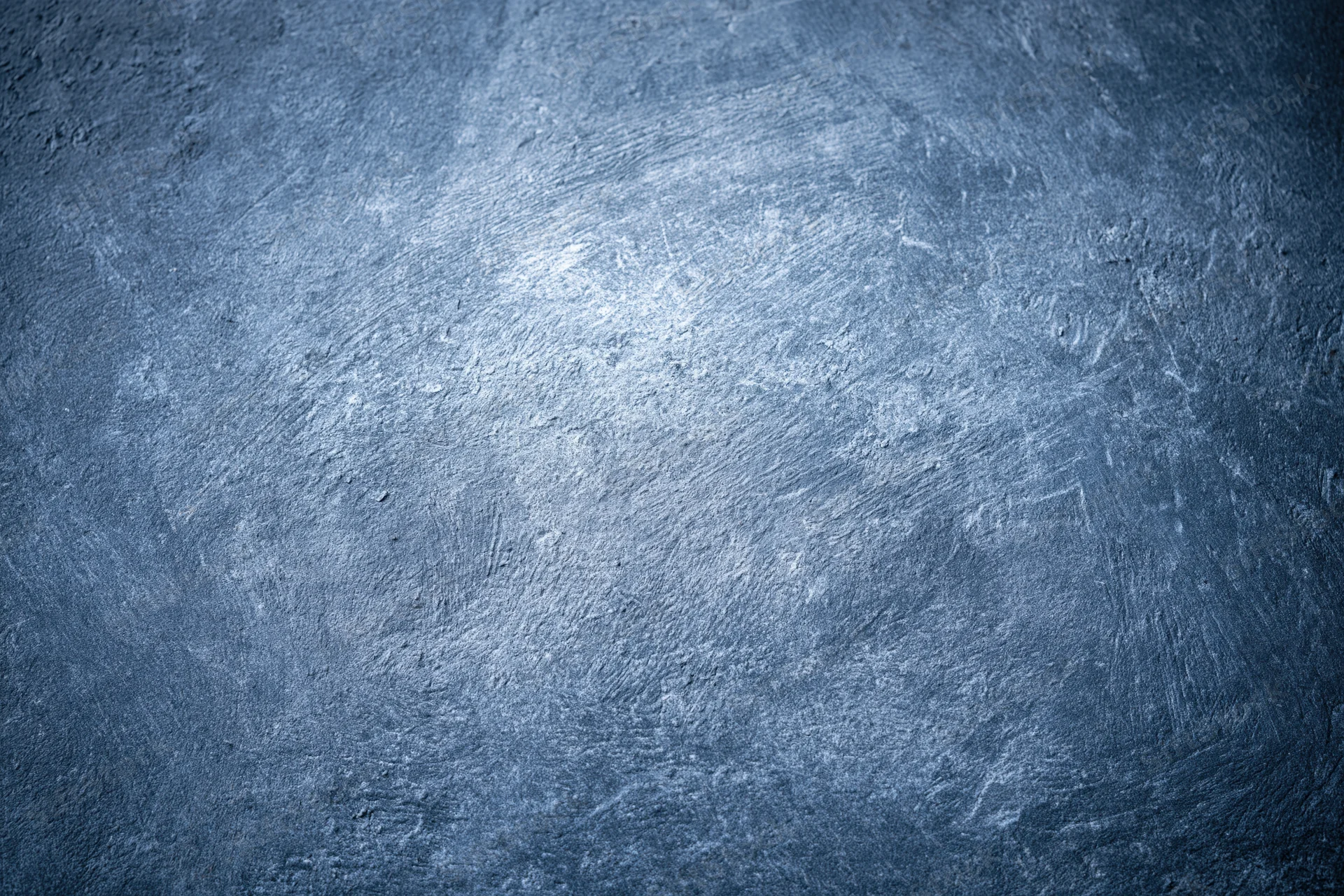 Weathered concrete wall surface filling the frame with textured gray-blue finish