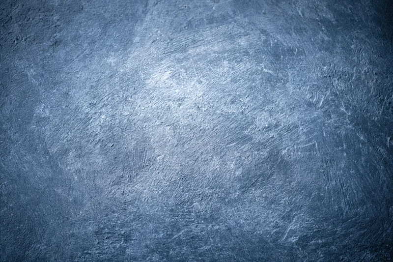 Weathered concrete wall surface filling the frame with textured gray-blue finish