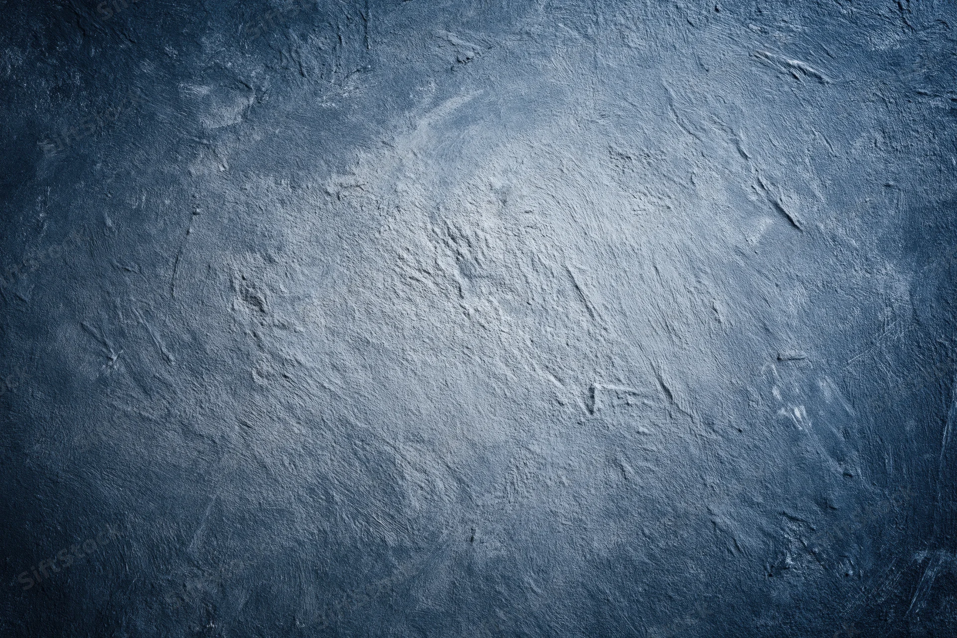 Weathered concrete wall surface filling the frame with textured gray-blue finish