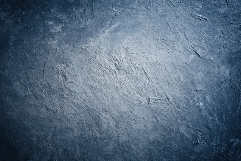 Weathered concrete wall surface filling the frame with textured gray-blue finish