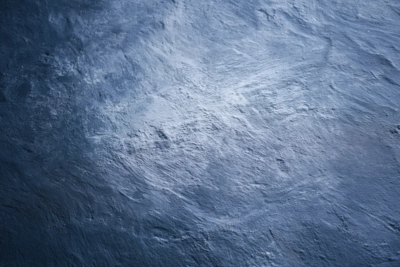 Weathered concrete wall surface filling the frame with textured gray-blue finish