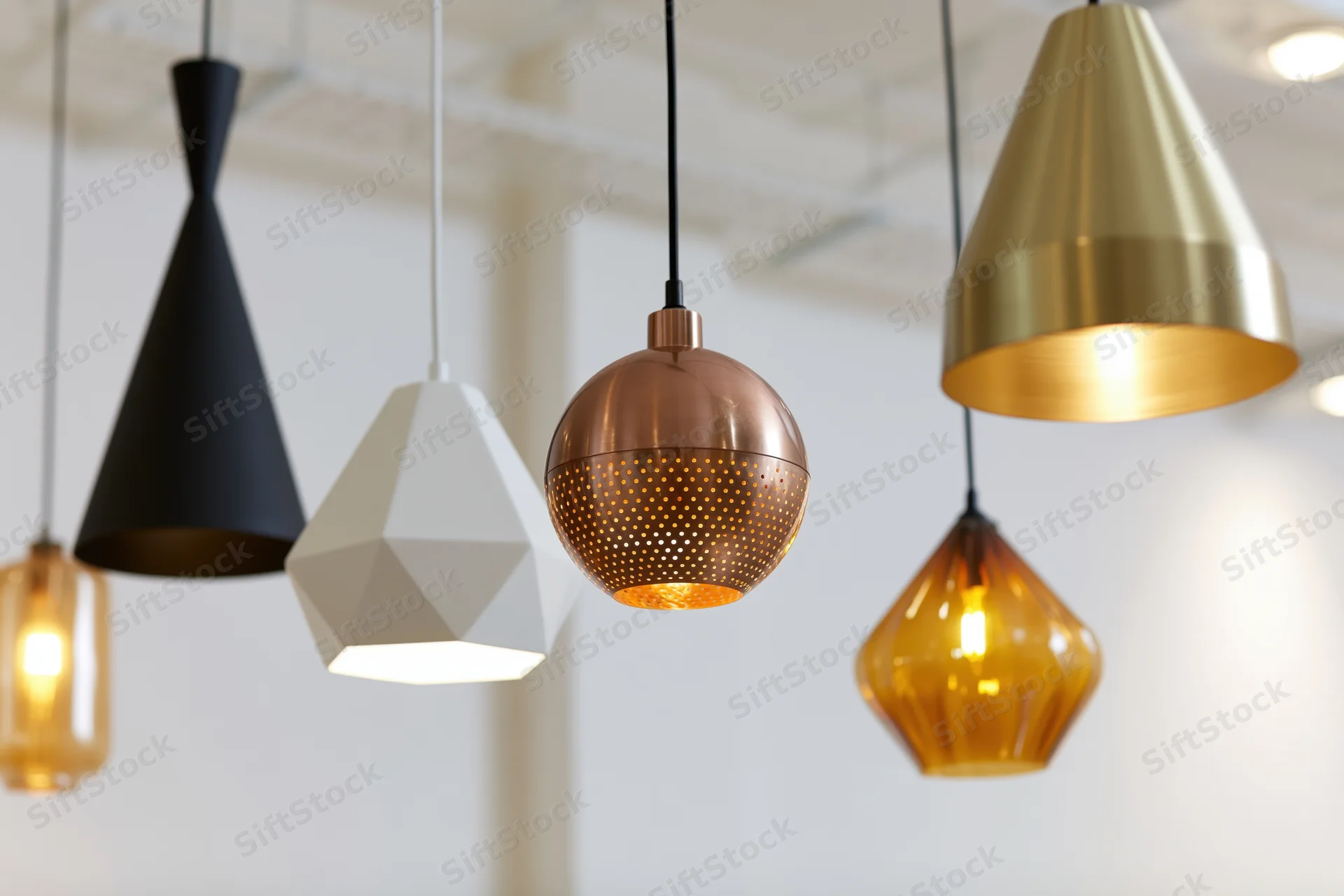 Modern pendant lamps hanging at varying heights in a bright interior space