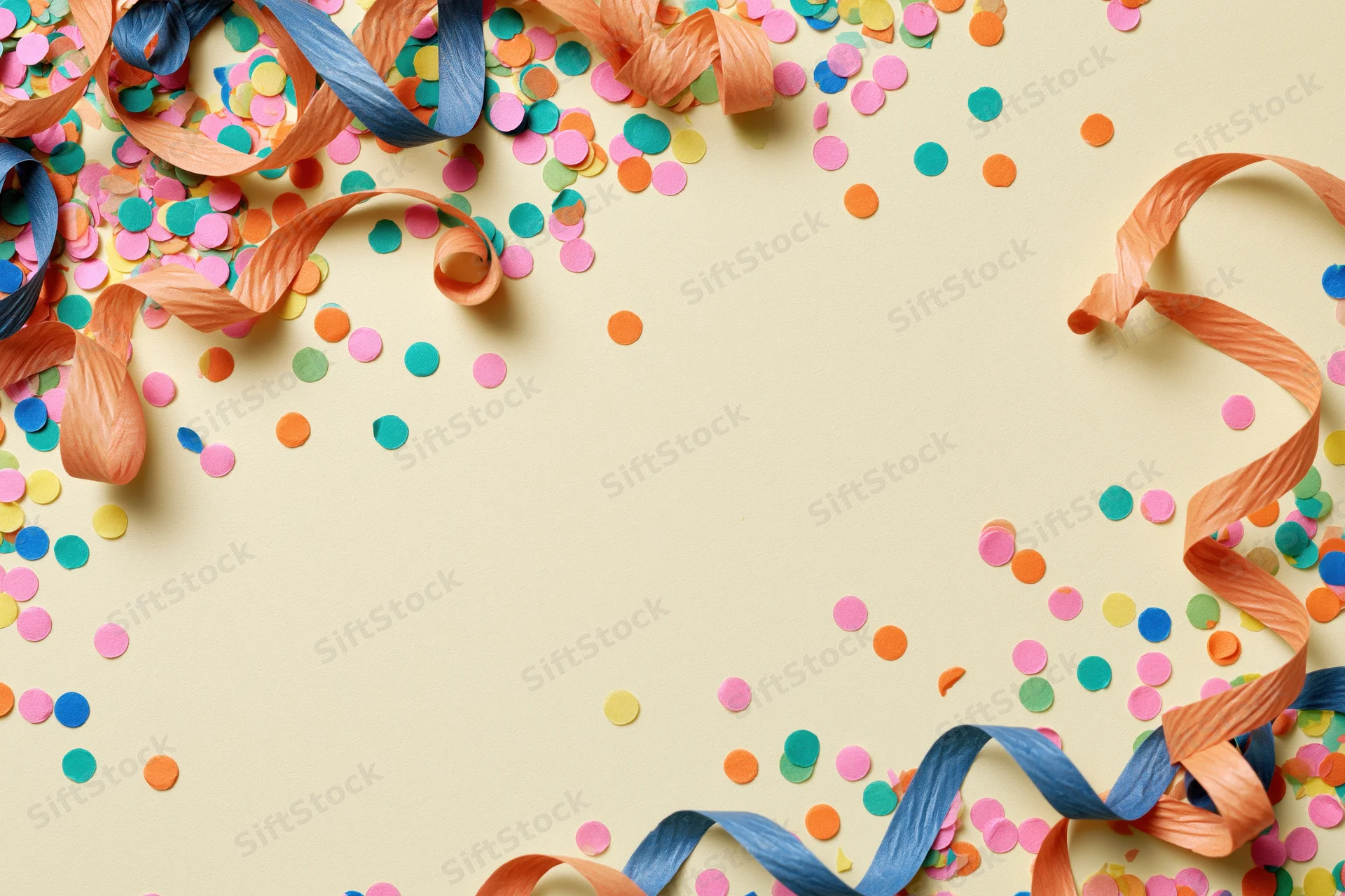 Colorful confetti dots and curled paper streamers scattered across a light beige surface forming a festive border with copyspace in the center