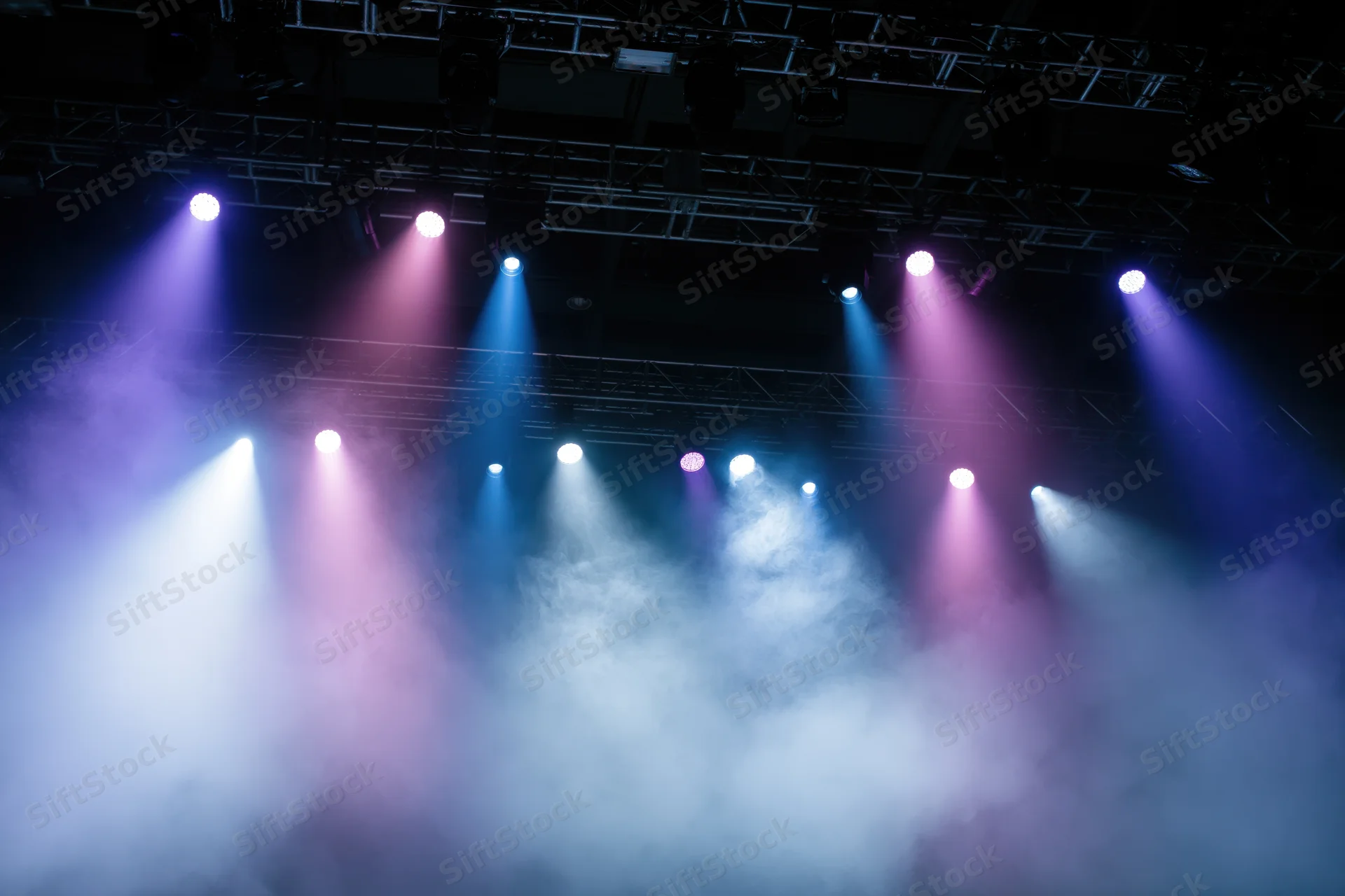 Stage lighting rig with colorful spotlights and smoke below the truss structure
