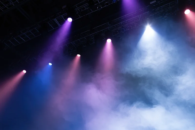 Stage lighting rig with colored spotlights and smoke viewed from below