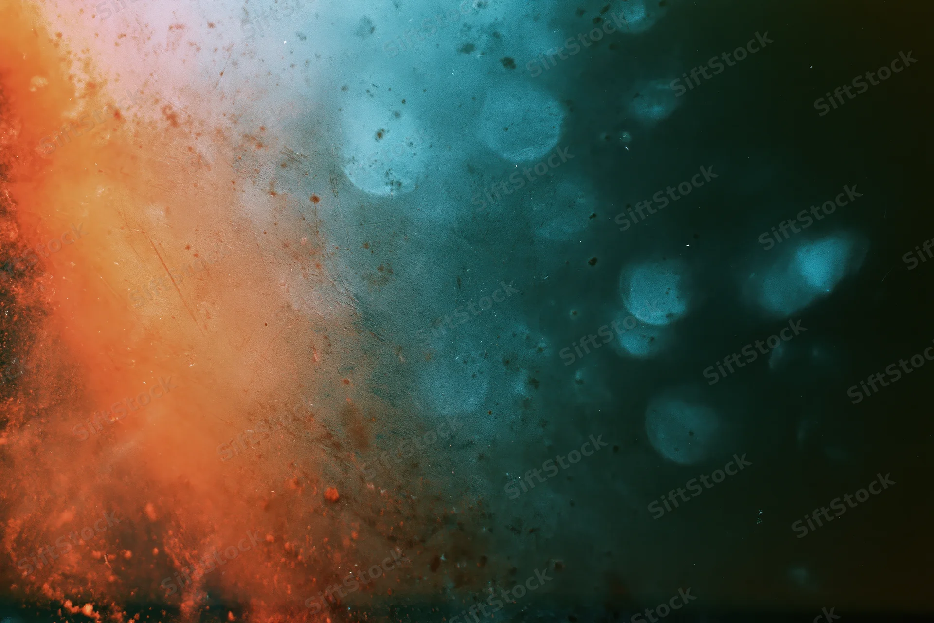 Damaged 35mm film frame showing light leaks and lens flare with orange and blue color bleed across the surface
