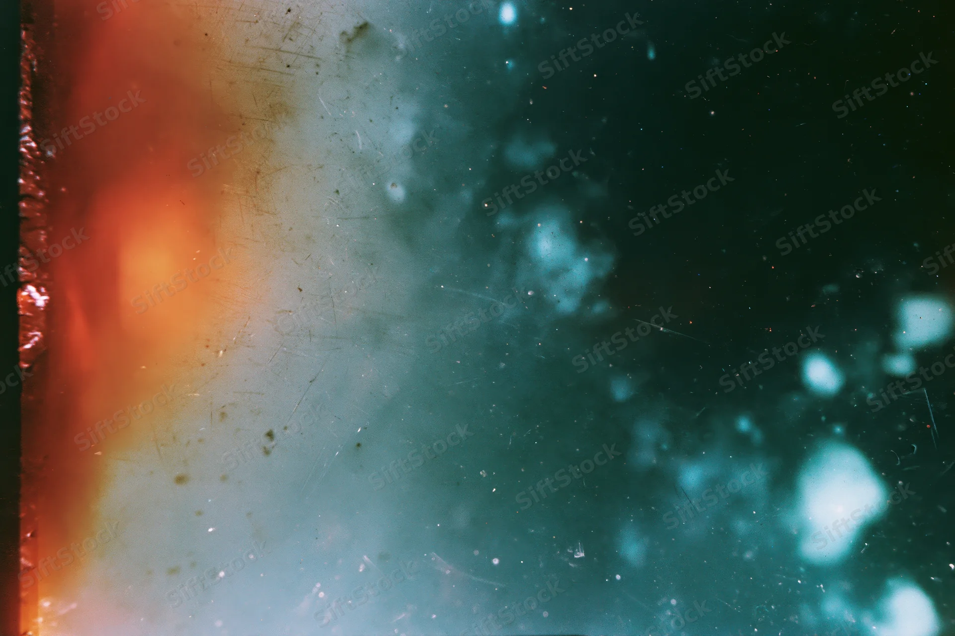 Damaged 35mm film frame showing heavy light leaks and lens flare with orange and teal color gradients and bokeh effects