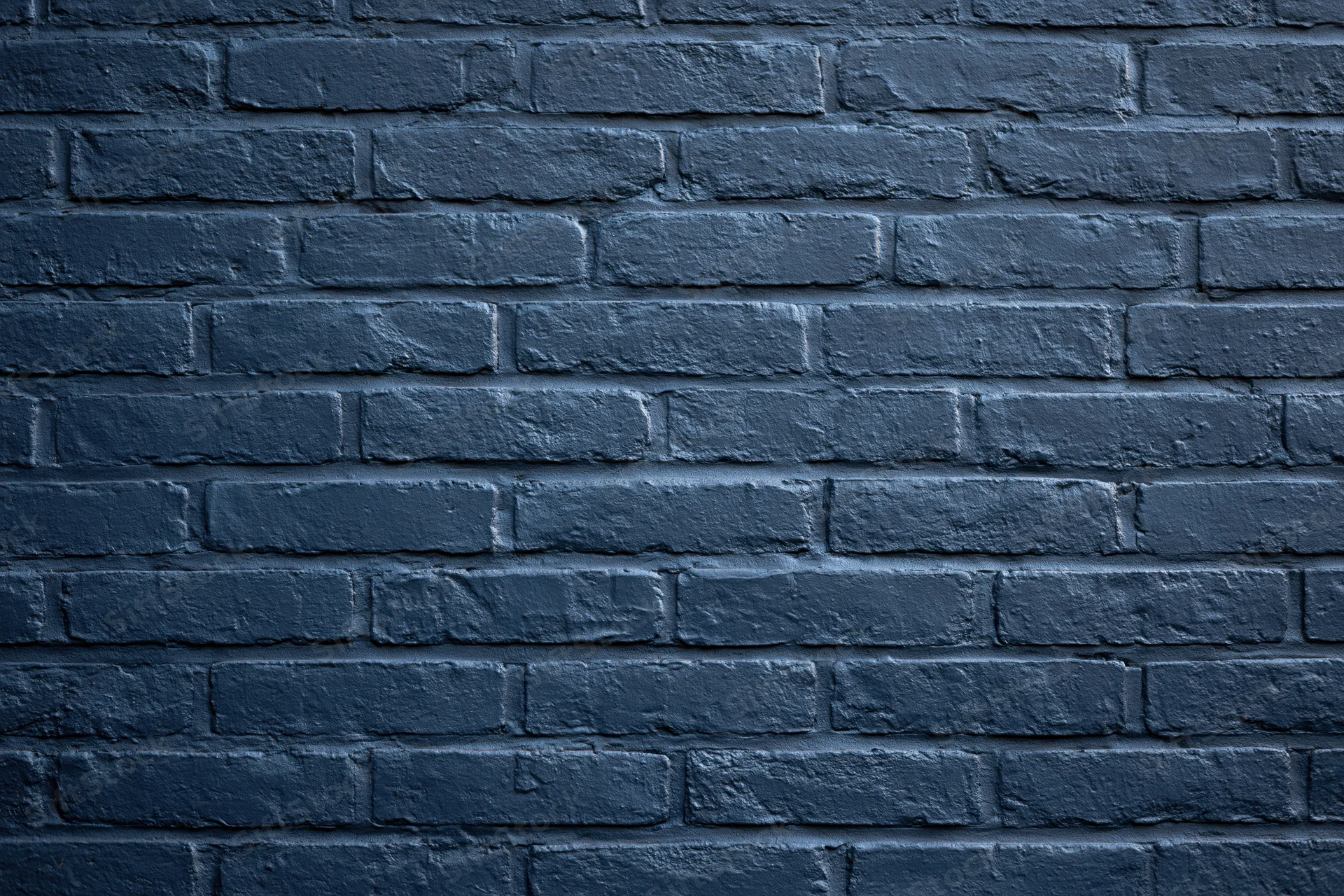 Navy-painted brick wall filling the frame flat-on as a textured background