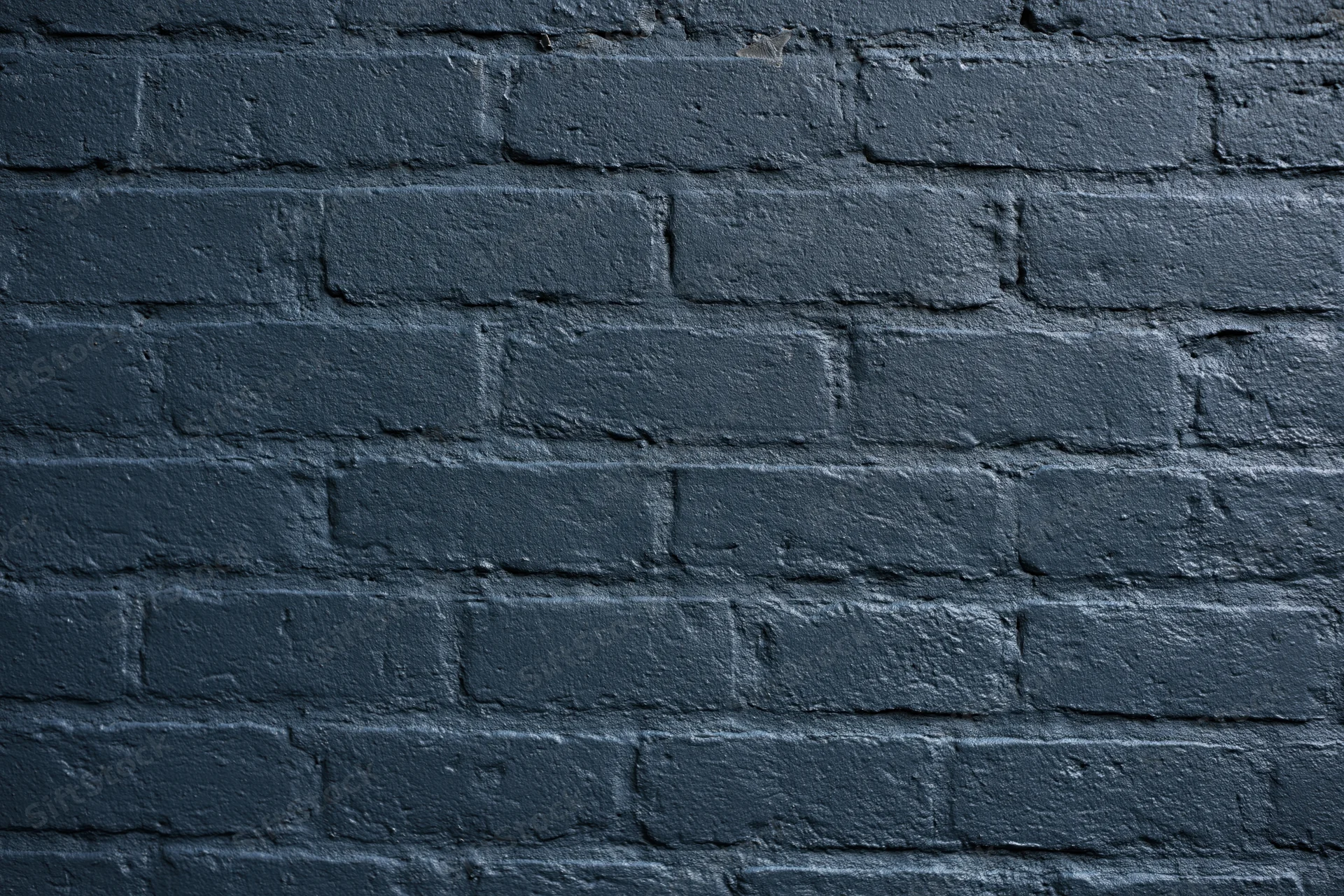 Dark navy-painted brick wall filling the frame flat-on