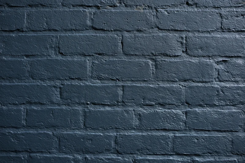 Dark navy-painted brick wall filling the frame flat-on