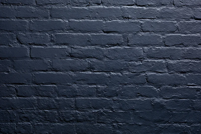 Navy-painted brick wall filling the frame flat-on